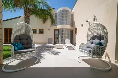 two wicker chairs sitting on a patio at Villa Perla del Mare in Alcamo Marina