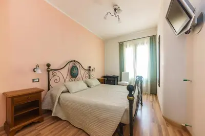 a bedroom with a bed and a television on the wall at Residence Mareluna in Castellammare del Golfo