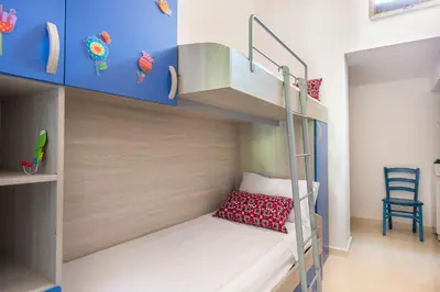 a small bedroom with bunk beds with a ladder at La Casa di Sara a Mondello by Wonderful Italy in Mondello