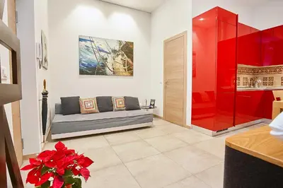 a living room with a couch and a red wall at KMC suites - Red in Palermo