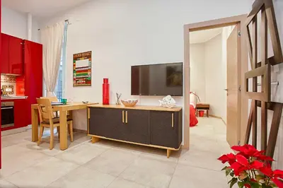a living room with a desk with a television on it at KMC suites - Red in Palermo