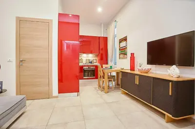 a living room with a television and a red wall at KMC suites - Red in Palermo