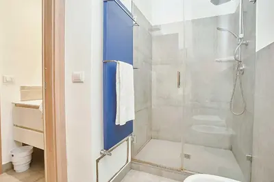 a bathroom with a glass shower with a toilet at KMC suites - Purple in Palermo
