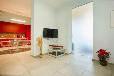 a living room with a tv on a wall at KMC suites - Purple in Palermo