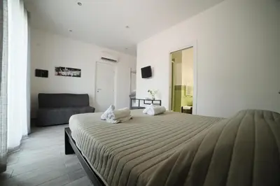 a bedroom with a large bed and a couch at Cavour37 Rooms in Palermo