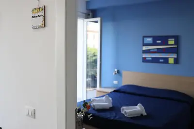 a blue bedroom with a bed with two pillows on it at Cavour37 Rooms in Palermo
