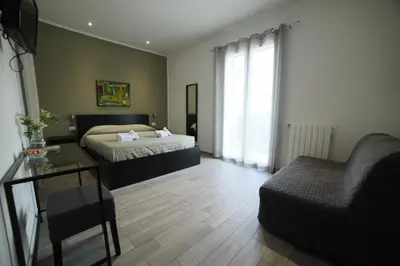 a bedroom with a bed and a chair and a couch at Cavour37 Rooms in Palermo