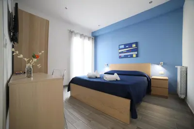 a blue bedroom with a bed and a television at Cavour37 Rooms in Palermo