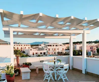 a white pergola on a balcony with a table and chairs at Appartamento Le Ginestre in San Vito lo Capo