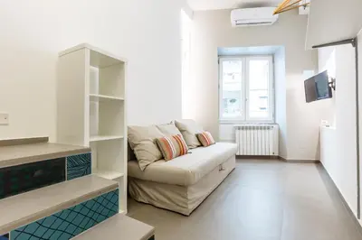 a living room with a couch and a tv at Loft Piazza Marina Family by DomuSicily in Palermo