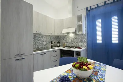 a kitchen with a table with a bowl of fruit on it at Al Baglio in Castellammare del Golfo