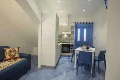 a room with a bed and a table and a kitchen at Al Baglio in Castellammare del Golfo
