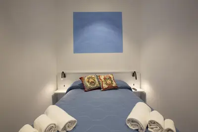 a bedroom with a blue bed with two pillows at Al Baglio in Castellammare del Golfo