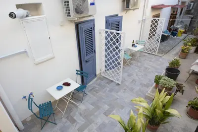 a balcony with blue doors and chairs and plants at Al Baglio in Castellammare del Golfo