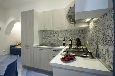 a kitchen with a stove and a bowl of fruit on a counter at Al Baglio in Castellammare del Golfo