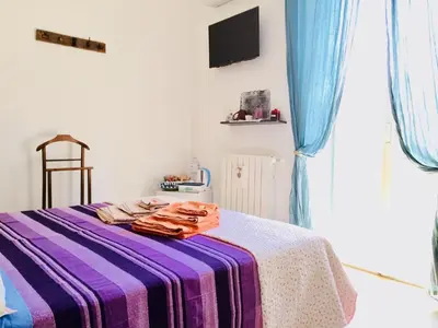 a bedroom with a bed with a purple and white blanket at Gò Gò House in Palermo