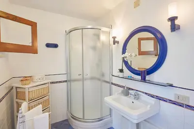 a bathroom with a shower and a sink and a mirror at Villa Majus in Porticello