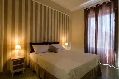 a bedroom with a large bed and a window at Mille e una Notte / Station Apartment in Palermo