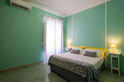 a bedroom with a bed with blue walls and a window at Mille e una Notte / Station Apartment in Palermo