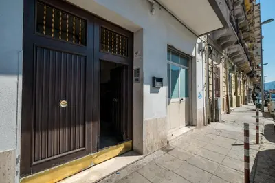a building with a brown door on a street at Mille e una Notte / Station Apartment in Palermo