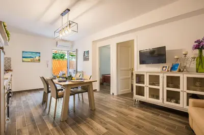 a dining room with a table and chairs and a tv at Villa Cinzia-150 mt from the beach in Mondello