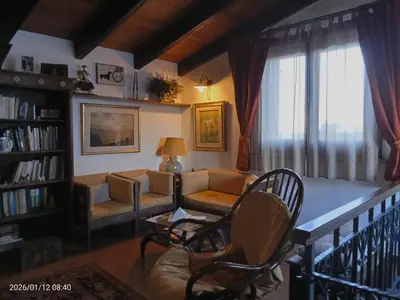 a living room with a book shelf and a painting at Villa Amalia - mansarda B&B in Cinisi