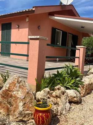 a house with a large rock in front of it at Villa Agapanthus in Castellammare del Golfo