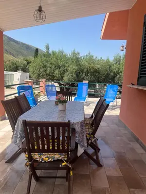 a table and chairs on a patio with a view at Villa Agapanthus in Castellammare del Golfo