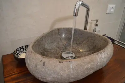 a stone sink with a faucet in a bathroom at Villa Agapanthus in Castellammare del Golfo