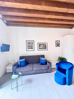 a living room with a blue couch and a table at Capo Loft in Palermo