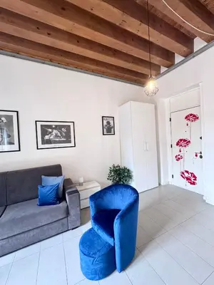 a living room with a couch and a blue chair at Capo Loft in Palermo