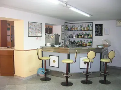 a bar with stools and a counter with bottles at Hotel Villa Archirafi in Palermo