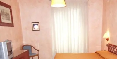 a bedroom with a bed and a tv and a window at Hotel Villa Archirafi in Palermo
