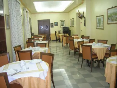 a dining room with tables and chairs with white table cloth at Hotel Villa Archirafi in Palermo
