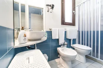 a blue and white bathroom with a toilet and a sink at Casa di Cecilia in Castellammare del Golfo