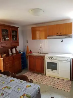 a kitchen with wooden cabinets and a white stove top oven at Casa Rosalba in San Vito lo Capo