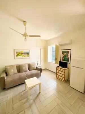a living room with a couch and a table at casa delle rose in Isola delle Femmine