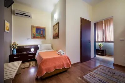 a bedroom with a bed with an orange blanket at Sky Sleeping in Palermo