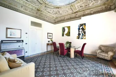 a living room with a table and chairs and a ceiling at Al Massimo Piacere in Palermo