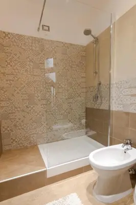 a bathroom with a shower and a toilet and a sink at La Bella Balla-rò Rooms in Palermo