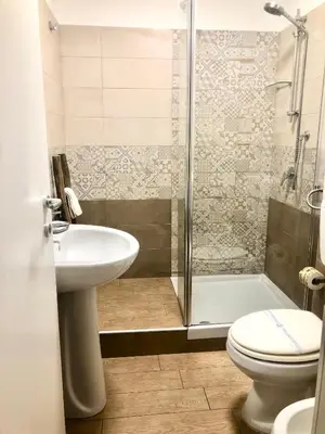 a bathroom with a shower and a sink and a toilet at La Bella Balla-rò Rooms in Palermo