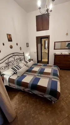 a bedroom with a bed with a striped comforter at David house alla Vucciria in Palermo