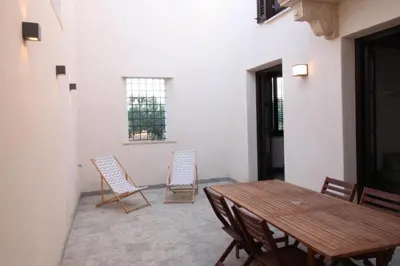 a dining room with a wooden table and chairs at Antico Baglio Siciliano in Balestrate