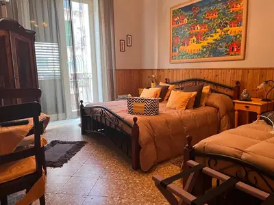 a bedroom with two beds and a painting on the wall at Nuovo Cortile Palermo Bed and Breakfast in Palermo