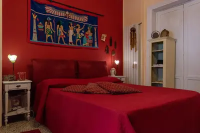 a red bedroom with a bed with a red bedspread at Nuovo Cortile Palermo Bed and Breakfast in Palermo