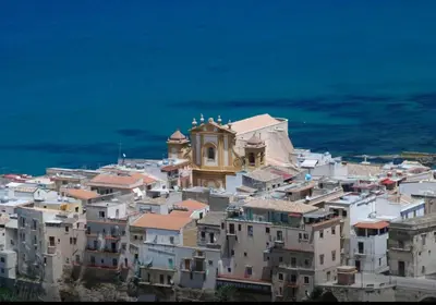 a cluster of buildings with a clock tower on top at Casa Vacanze Sea-Life in Alcamo Marina