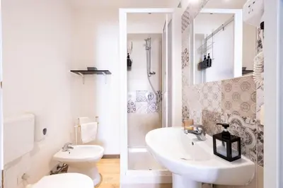 a white bathroom with a sink and a toilet at Il Sonaglio in Palermo