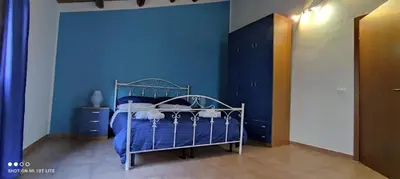 a blue bedroom with a bed and a blue wall at Casa Samu in Palermo