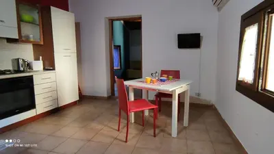 a kitchen with a white table and red chairs at Casa Samu in Palermo