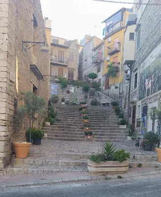 a set of stairs in an alley with plants at Villetta in Centro Storico in Caccamo